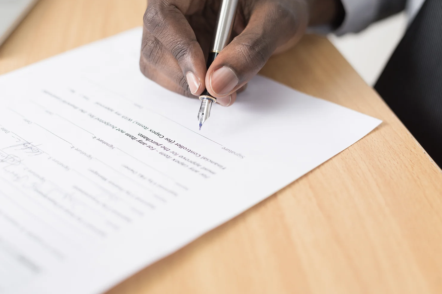 Person writing on sheet of paper