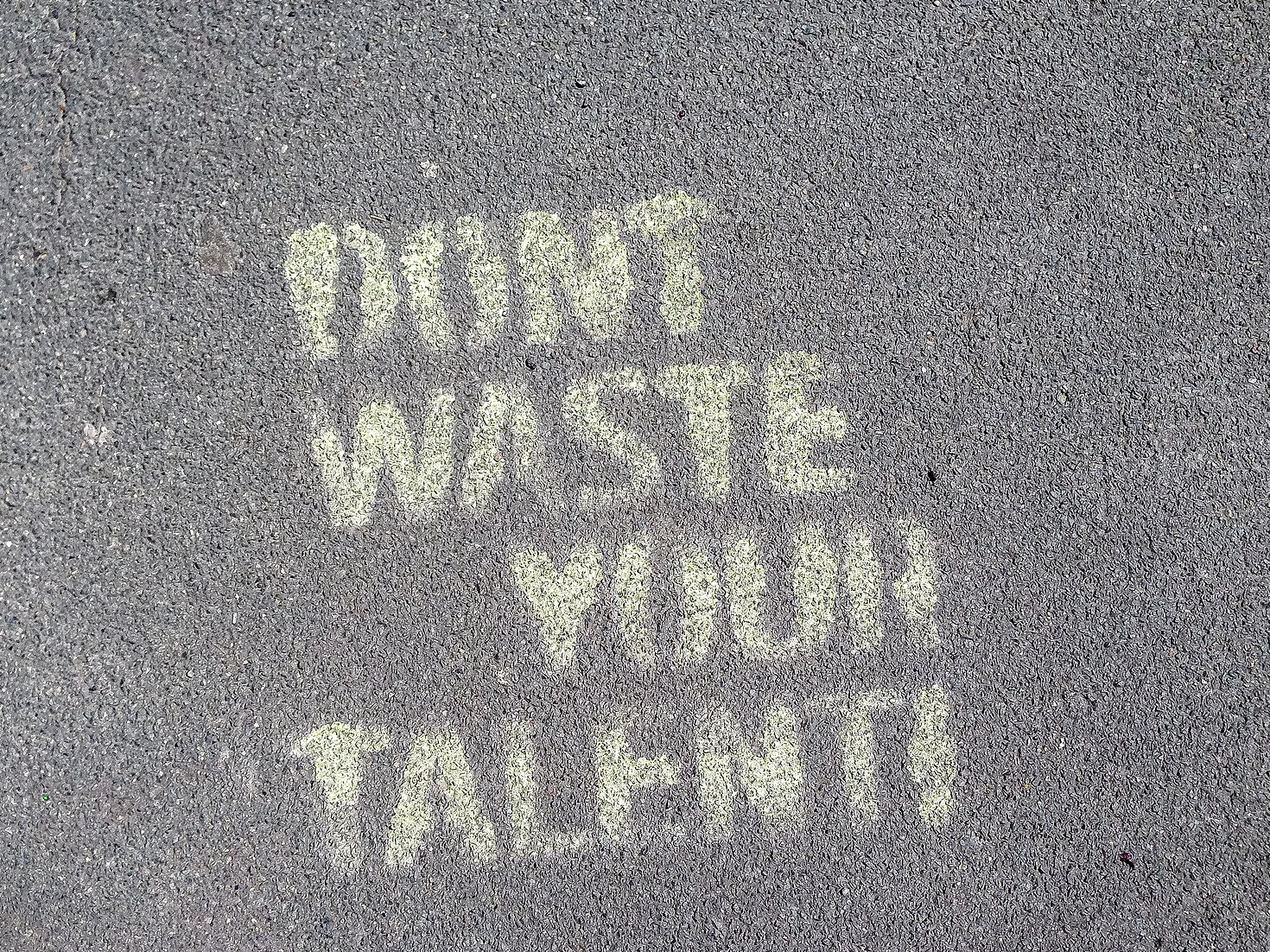 "Don't waste your talent" written on sidewalk